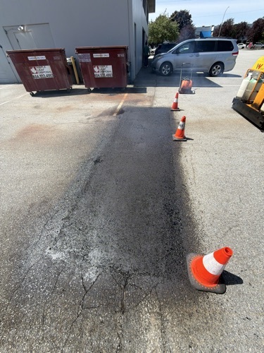 Repaired and seal-coated asphalt surface after Invictus work